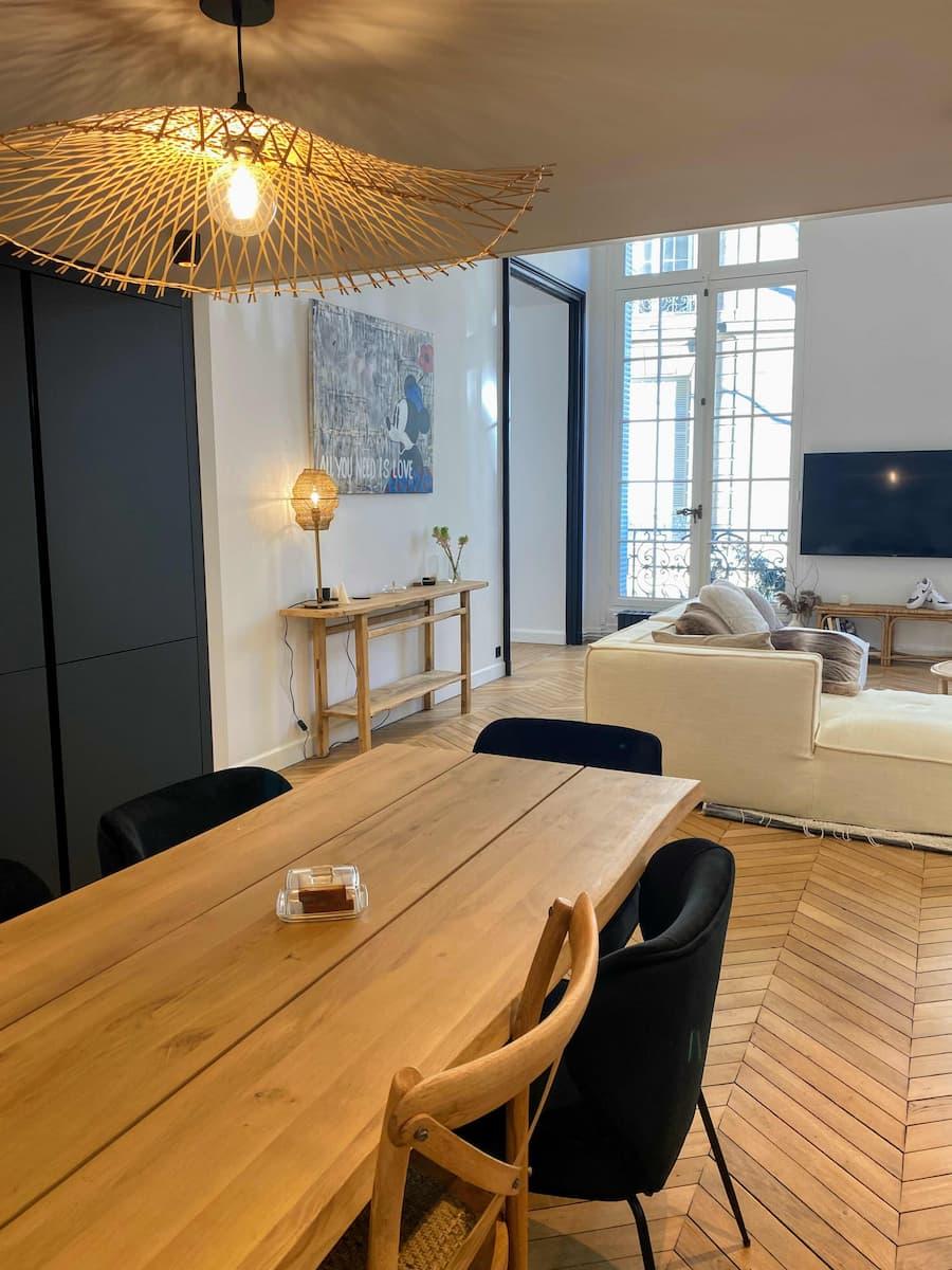 The dining table beneath a rattan pendant light