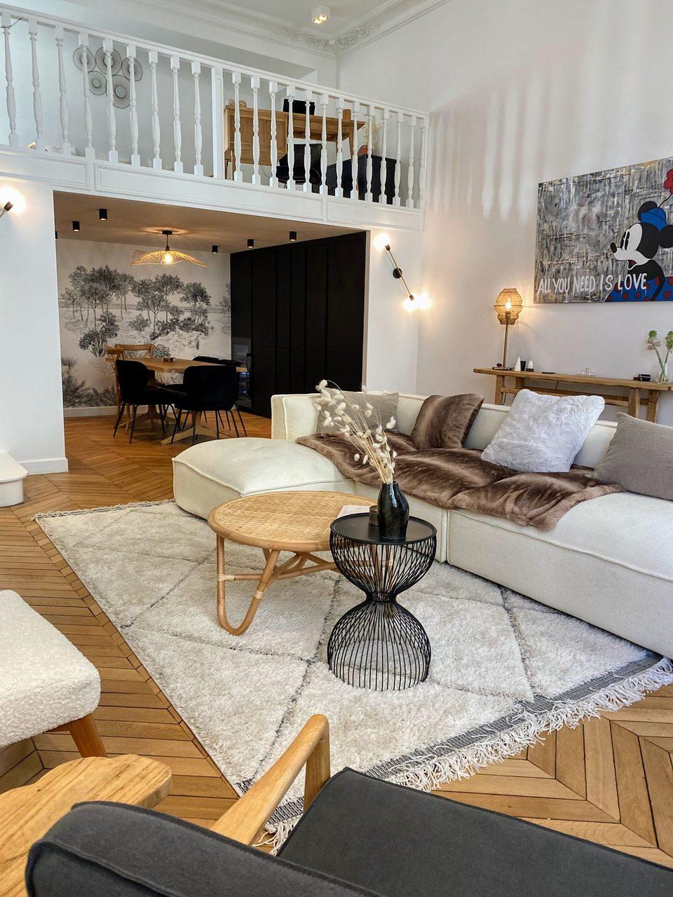 The living room beneath the mezzanine, with the dining area beyond