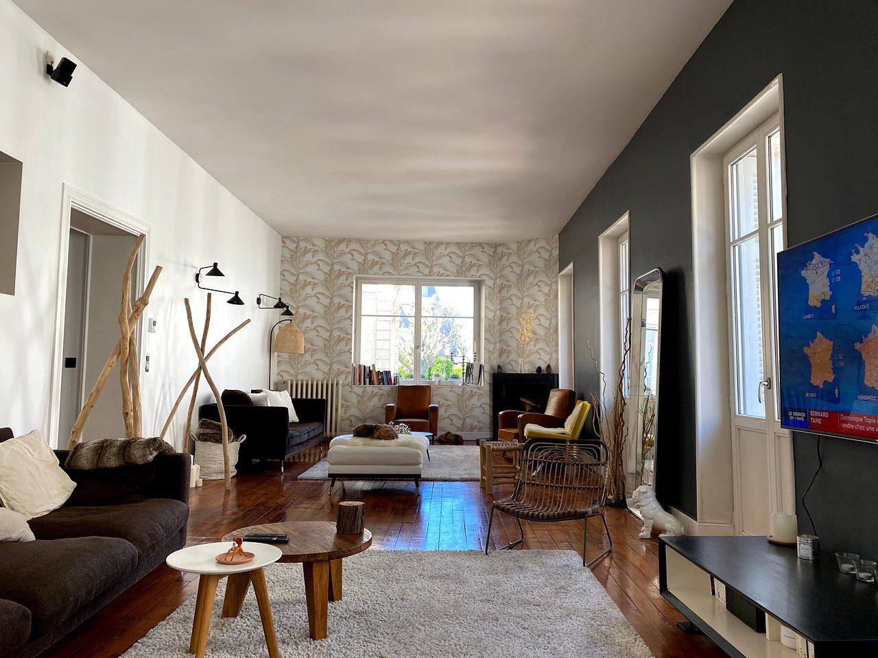 The double living room, with old parquet floors and leaf-pattern wallpaper